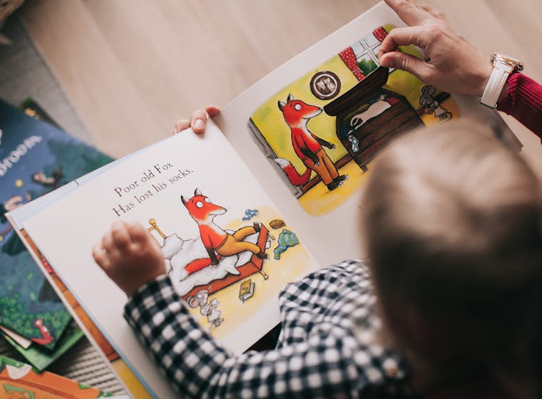 A child reading their own illustrated story